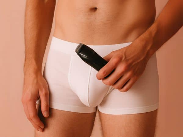 uomo con rasoio in mano per depilazione uomo genitali