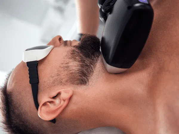 trattamento di epilazione laser sul collo di un uomo con occhiali protettivi